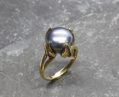 Black Pearl Ring set with Natural Pearl in a top quality & natural luster, at 12mm diameter, sourced from Japan sea water Farm. Gold Pearl Ring in Antique design made of Gold Vermeil ☞ thickest 18k Gold Plating on top of Solid 925 Sterling Silver ☞ made to last.. Matching Earrings: www.etsy.com/listing/788414324 Matching Pendant: www.etsy.com/listing/802289619 June Birthstone - Genuine & Natural Stones ❀ ☞ Choose your size ☞ I resize (before shipping) for FREE to Any size* ⌛Last Ring left ⌛ ❀ Ea Pearl Ring Design, Pearl Gold Ring, Black Pearl Ring, Black Pearl Earrings, Gold Leaf Rings, Natural Emerald Rings, Gold Flower Ring, Pearl Jewelry Design, Pearl Engagement Ring