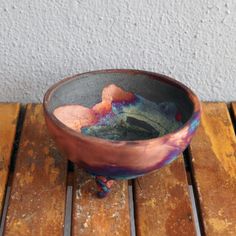 a bowl sitting on top of a wooden table