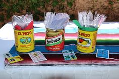 three jars filled with tins sitting on top of a table next to each other