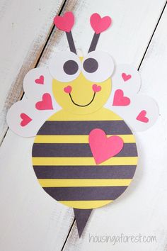 a paper cut out of a bee with hearts on it