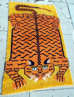 a rug with an image of a tiger on it's face is shown in front of a sidewalk