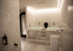 a bathroom with three sinks and two urinals