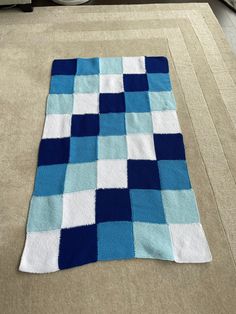 a blue and white blanket laying on the floor in front of a stove top oven