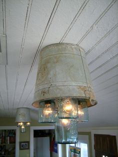 a chandelier hanging from the ceiling in a room with white paint and light bulbs