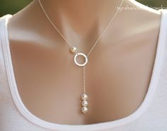 An elegant karma circle necklace with a pearl string pendant 1. a 8mm Swarovski white/ivory pearl above 2. a sterling silver karma circle (smooth or hammered surface) 3. a string of three Swarovski pearls at the end of the dangled chain 4. a sterling silver chain with a lobster Easy Jewelry Making Ideas Simple, Sterling Silver Lariat Pearl Necklace For Wedding, Elegant Personalized Jewelry With Round Beads, Elegant Personalized Round Bead Jewelry, Sterling Silver Pearl Drop Lariat Necklace As Gift, Sterling Silver Lariat Necklace With Pearl Drop As Gift, Minimalist Pearl Lariat Necklace As Gift, Minimalist Pearl Lariat Necklace For Gift, Elegant Single Strand Lariat Necklace For Gift