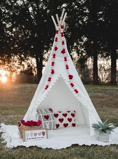 a teepee with hearts on it sitting in the grass