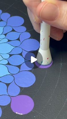 someone is using a marker to paint the flower design