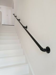 a set of stairs leading up to the second floor with black railing and handrails