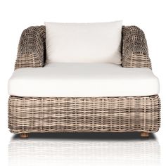 a wicker lounge chair with white cushions