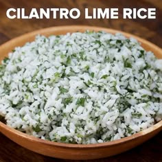 a wooden bowl filled with rice on top of a table