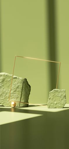 an object is sitting on the ground near some rocks and a small gold bead