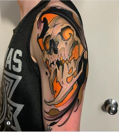 a man's arm with a skull and flames tattoo on the left side of his arm