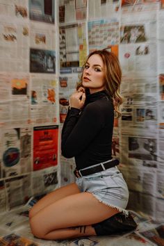 a woman sitting on top of a bed next to a wall