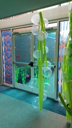 a room that has some balloons hanging from it's ceiling in front of a window