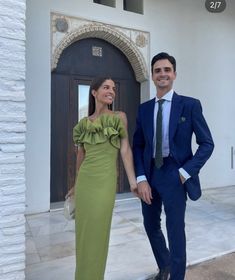 a man and woman standing in front of a building