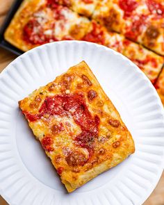 a piece of pizza sitting on top of a white paper plate