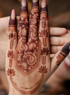 a woman's hand with henna tattoos on it