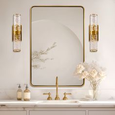 a bathroom with two sinks and a large mirror on the wall above it that has flowers in vases