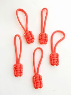 four red ropes tied together on a white surface