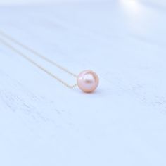 "Price is for one beautiful peachy pink Edison floating pearl necklace. Photos may feature multiple necklaces that can be purchased separately. If you are looking for Bridal Party or Bridesmaids sets, please contact me for pricing information. This chain is made from your choice of either gold filled or sterling silver and will not tarnish and can even get wet! We HIGHLY recommend selecting double rope chain (more durable) for longer necklaces 22\"-26\". Pearls are approximately 10-11mm round/ne Pink Gold Pearl Jewelry For Gift, Pink Gold Pearl Jewelry Gift, Pink Round Pendant Necklace For Wedding, Dainty Pink Pearl Necklace For Wedding, Peach Pearl Jewelry As Gift, Rose Gold Single Strand Necklace For Gift, Rose Gold Single Strand Necklace As Gift, Pink Round Pendant Necklaces For Wedding, Pink Pearl Pendant Necklace As Gift