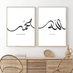 two black and white posters with arabic calligraphy on the wall above a wooden table