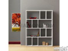 a white book shelf with an orange tree in the background and books on it's shelves