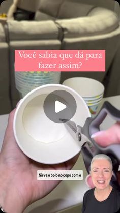 a person holding a pair of scissors in front of a table with coffee cups on it