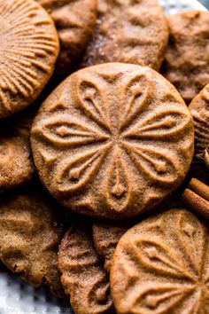 some cookies are on a plate with cinnamon sticks