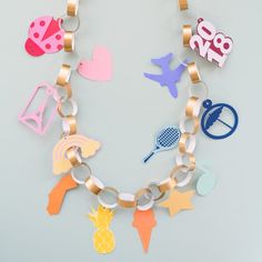 a bracelet made out of paper cut outs and metal chains with various items attached to it