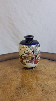 a blue and white vase sitting on top of a wooden table