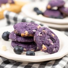 three cookies with blueberries and white chocolate chips on a plate