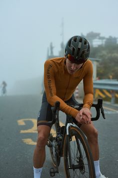 a man riding on the back of a bike down a street next to a road