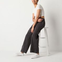 These Arizona women's low-rise cargo pants are a stylish utilitarian pair to sport for off-duty days. Made from 100% cotton, this wide-leg style has a baggy-fit, drawstring waist and side slip pockets. Team it with a tank top or a graphic tee. Front Style: Flat FrontClosure Type: Full ElasticFit: Baggy FitPockets: 2 Side Slip PocketsRise: Low RiseBase Material: 100% CottonFiber Content: 100% CottonFabric Description: WovenLining: UnlinedInseam: 32 InLeg Style: Wide LegCare: Machine WashCountry o Mid-rise Cotton Cargo Parachute Pants, Utility Cotton Mid-rise Parachute Pants, Sporty Cotton Parachute Pants For Work, Sporty Bottoms With Cargo Pockets For Everyday, Everyday Sporty Cargo Bottoms, Sporty Everyday Cargo Bottoms, Sporty Everyday Cargo Style Bottoms, Sporty Wide Leg Cargo Jeans In Cotton, Sporty Cotton Cargo Pants For Work