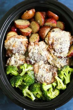 a crock pot filled with meat, potatoes and broccoli