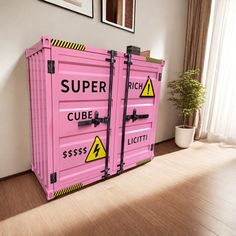 two pink shipping containers sitting on top of a hard wood floor next to a potted plant