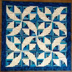 a blue and white quilt on a wooden floor