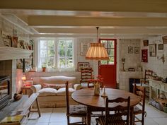 a living room filled with furniture and a fire place next to a table in front of a fireplace