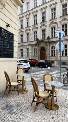 tables and chairs are set up in front of a building on a cobblestone street