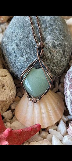 Product Title: Handcrafted Natural Aventurine Pendant - Copper Wire Wrap Design  Product Description: This unique and elegant pendant features a captivating Aventurine, a true gem of nature's beauty. The stone is intricately wrapped with copper wire, accentuating its natural sparkle. Each pendant is handcrafted, making it the perfect accessory to add a touch of elegance to any outfit. Due to the natural properties of the stone, each piece is one of a kind, ensuring your necklace is as unique as Aventurine Jewelry With Natural Stones In Round Pendant, Healing Aventurine Round Pendant Jewelry, Aventurine Round Pendant Gemstone Jewelry, Aventurine Gemstone Round Pendant Jewelry, Aventurine Gemstone Pendant Jewelry, Handmade Aventurine Pendant Jewelry, Aventurine Gemstone Bead Pendant Jewelry, Handmade Aventurine Round Pendant Jewelry, Aventurine Gemstone Round Pendant Necklace