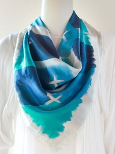 This large square scarf is hand painted in bold water colour brush strokes in perennial blue, midnight and aqua. Soft and luxurious satin silk with high sheen, outlined with a silver shimmer- this scarf is can be styled in multiple ways.  A must have in the wardrobe! 100% Silk Colour: Midnight Blue/Aqua Size: 90cm Square Hand rolled hem Blue Hand Painted Silk Scarf, Artistic Hand Dyed Blue Silk Scarf, Artistic Blue Silk Scarf, Water Colour Brush, Colour Brush, Large Square Scarf, Square Silk Scarf, Hand Roll, Satin Silk