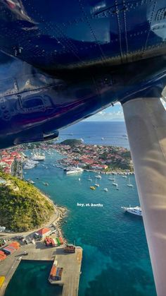 the view from inside an airplane looking down at boats in the water and on land