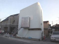 a white building on the side of a street with cars parked in front of it