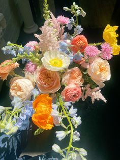 a vase filled with lots of different colored flowers