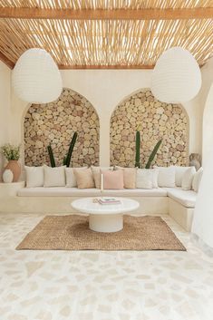 a living room with couches and tables on the floor in front of a bamboo roof