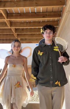 a young man and woman dressed up as fairy dusters, standing next to each other