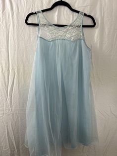 Add a touch of vintage glamour to your lingerie collection with this beautiful Movie Star Babydoll Chemise Peignoir Gown. The blue color gives a feminine and elegant feel, perfect for any balletcore fairy out there. Made of high-quality nylon material, this original vintage piece from the 1970/80s is a must-have for anyone who wants to make a statement. With a shoulder to hem length of 34 inches, this regular size M gown is perfect for a comfortable fit. It's important to note that this piece is being sold as is, without any mention of its condition. Don't miss out on the chance to add this unique and timeless piece to your collection. Fairycore feminine flowy festival preppy rave Sheer Nightgown For Wedding Night In Spring, Blue Nightgown For Wedding Night In Summer, Spring Party Lace Nightgown, Sheer Blue Nightgown, Spring Sheer Nightgown For Sleep, Spring Sheer Coquette Nightgown, Fitted Light Blue Sleepwear For Night, Light Blue Sheer Dress For Daywear, Spring Coquette Nightgown For Sleep