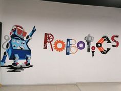 a white wall with some colorful letters on it and a robot painted on the wall