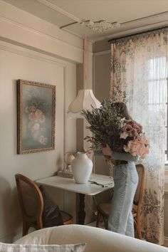 a woman is holding flowers in her living room