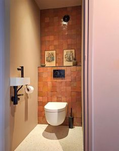 a bathroom with a toilet, sink and pictures on the wall above it's door