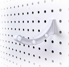 a close up of a white wall mounted device with holes on the side and dots all over it